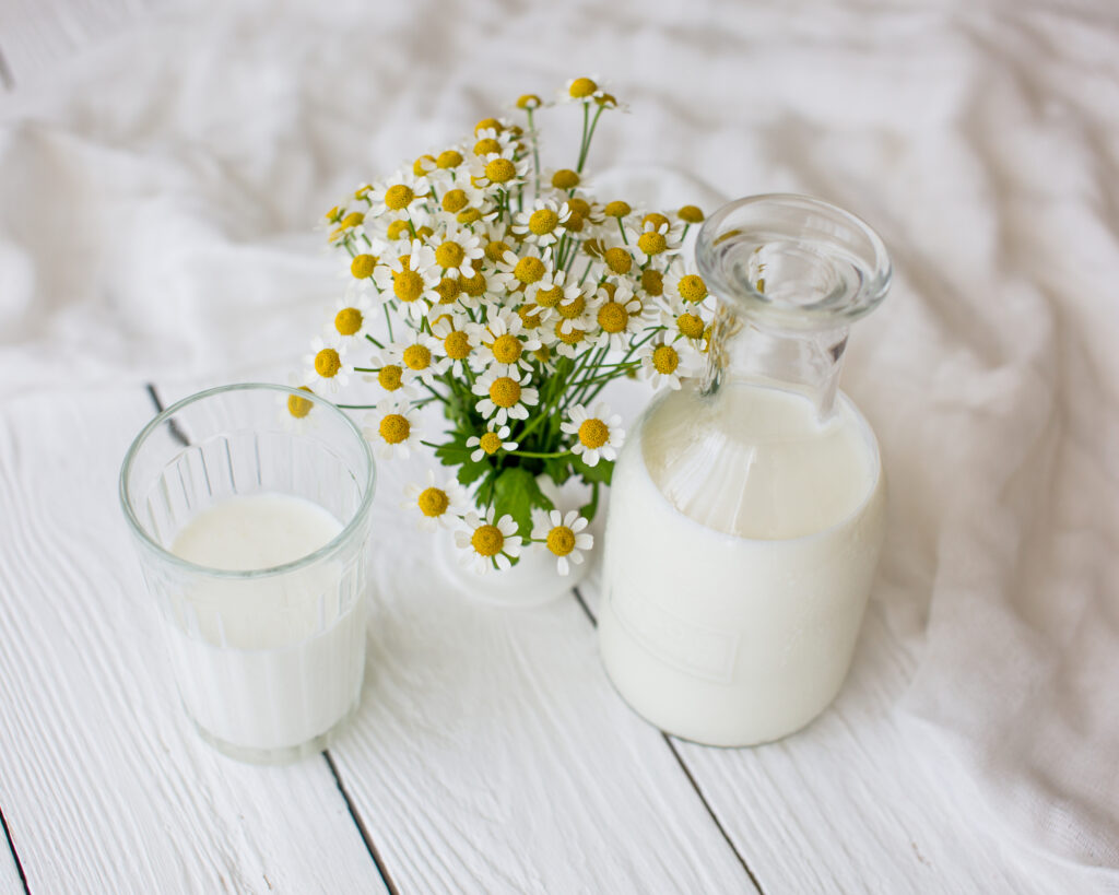 milk in jars with flowers on table